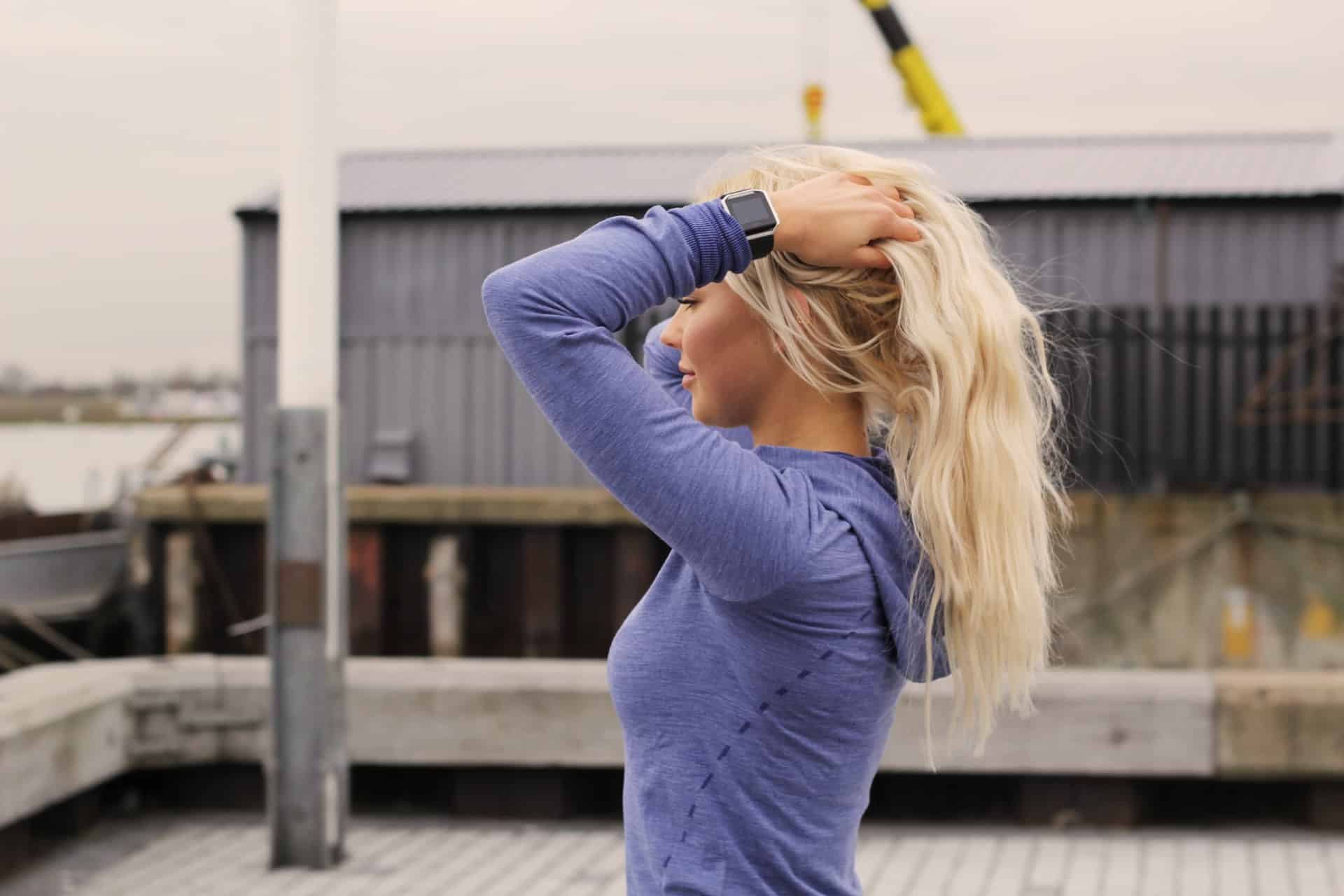 blond kvinna som sätter upp håret på taket
