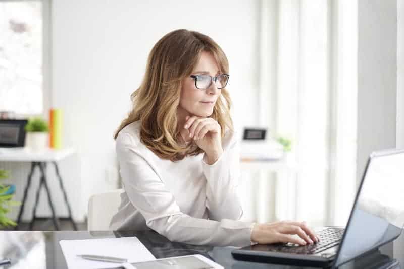 kvinna med glasögon tittar på laptop
