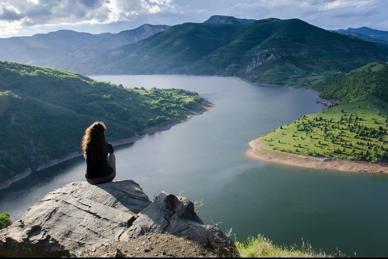 kvinna mediterar ensam på klippan
