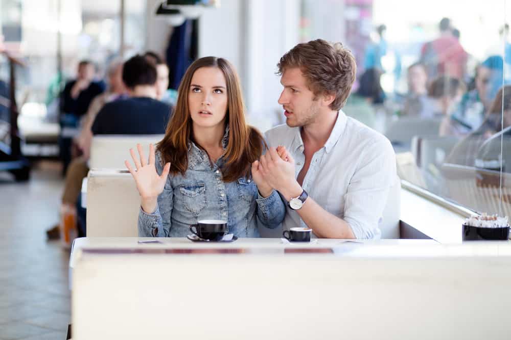 kvinna upprörd med mannen som sitter på café