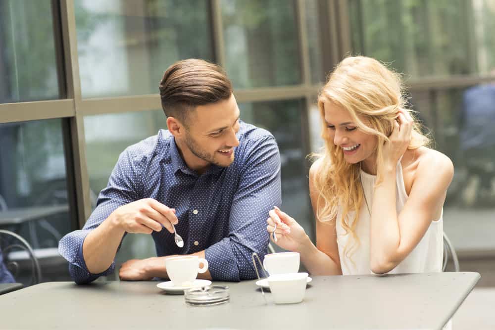 man och kvinna dricker kaffe och pratar