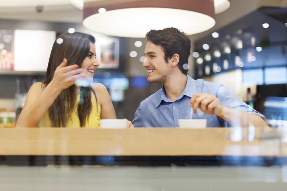 man och kvinna har intressant diskussion på café