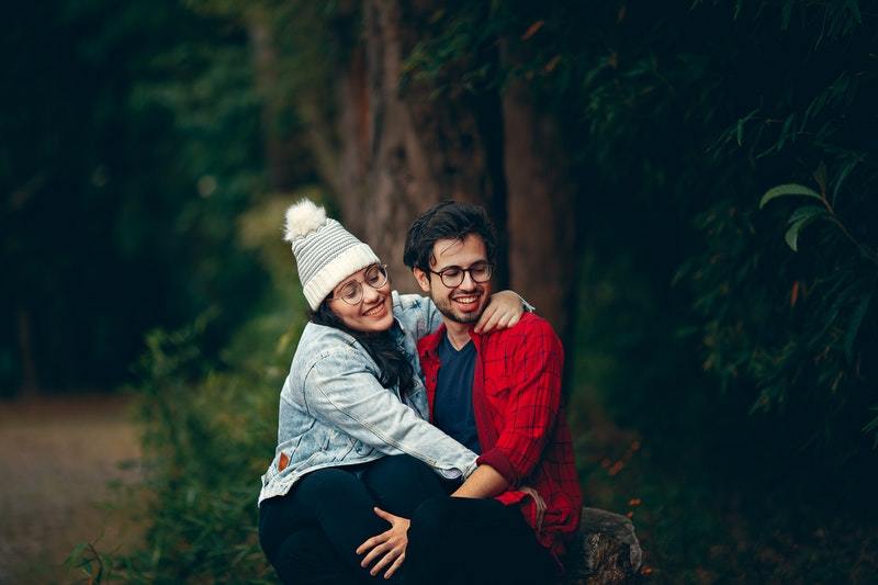 man och kvinna med glasögon som sitter i naturen