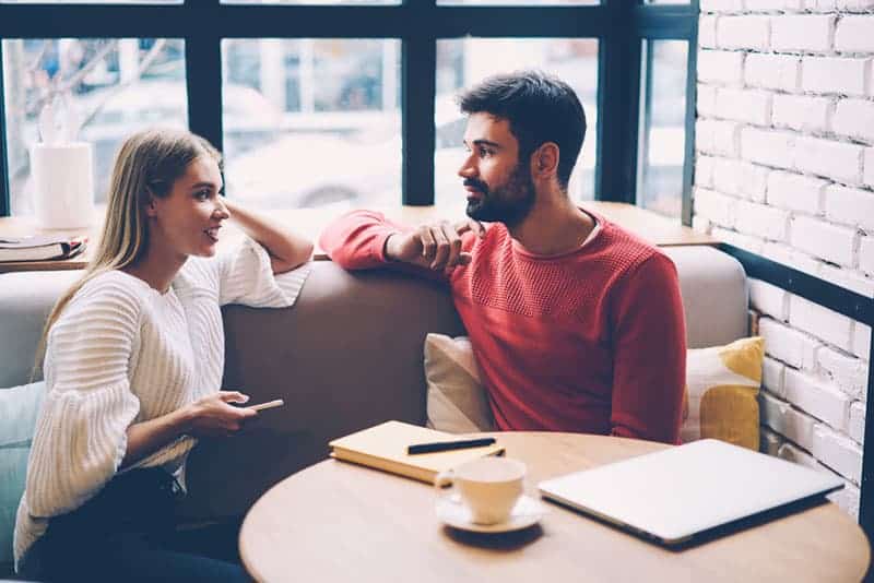 man och kvinna pratar på café