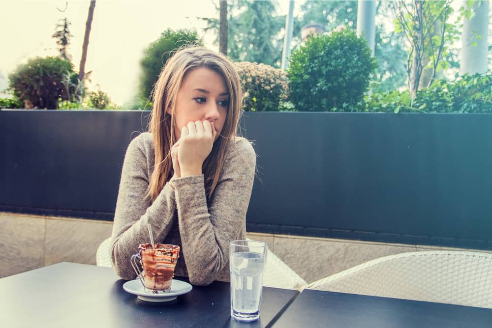 olycklig stressad vacker kvinna som sitter på café