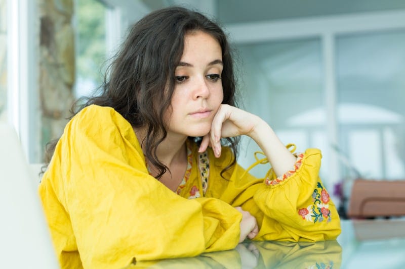 Stående av en upprörd ensam tjej klädd i en gul skjorta