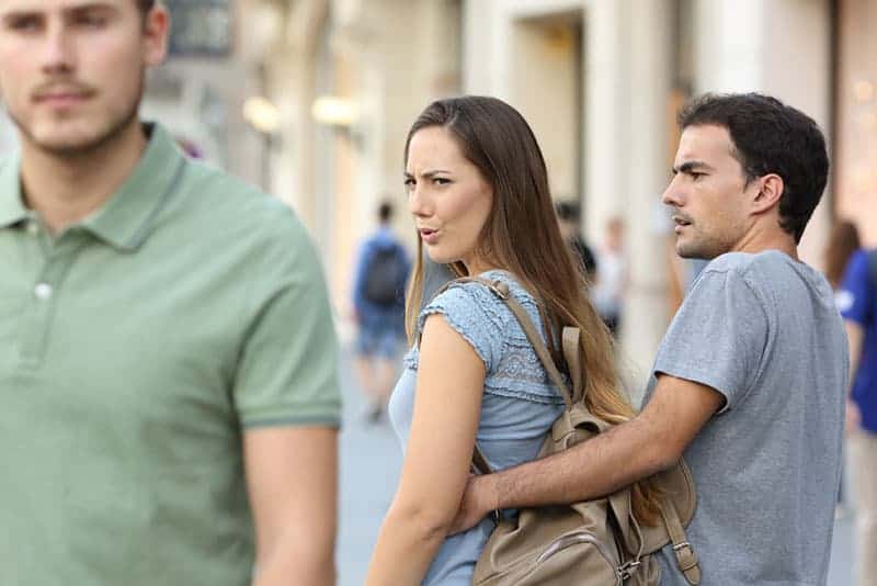 arg kvinna som tittar på mannen på gatan