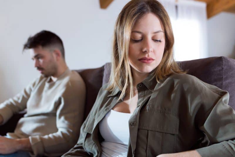 arg ungt par som sitter på soffan tillsammans