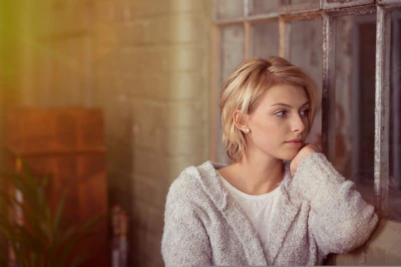 blond kvinna som bär tröja som sitter ensam