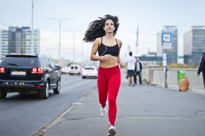en kvinna i röda leggings som joggar