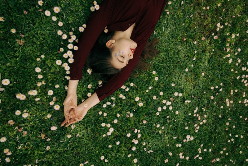 en kvinna som ligger på gräset