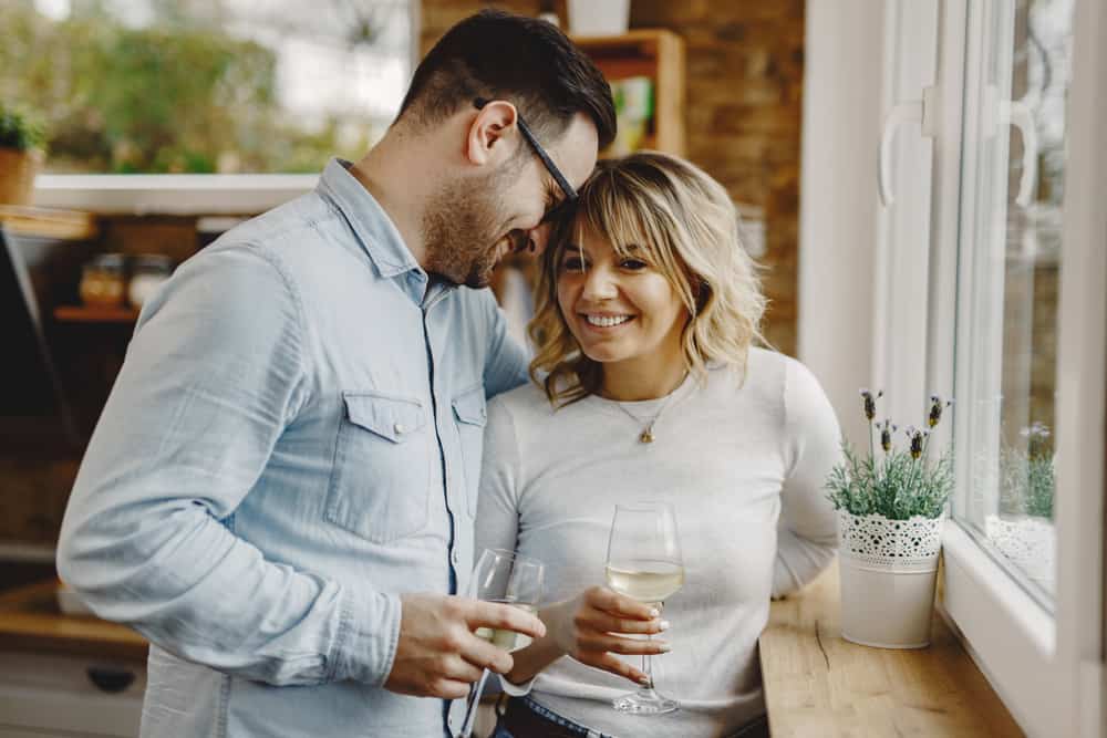 en man och en kvinna dricker vin och skrattar