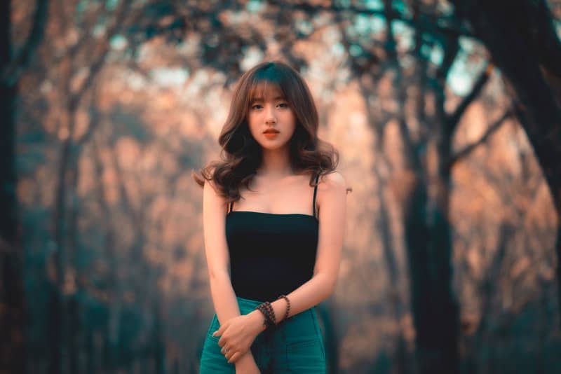 en vacker asiatisk kvinna står i skogen