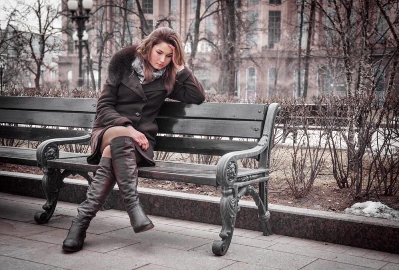 ensam kvinna som bär jacka som sitter på bänken