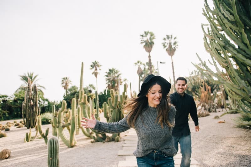 ett leende älskande par som kör nära en kaktus