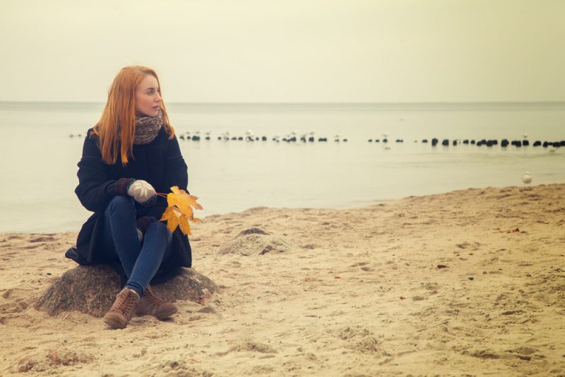 fundersam kvinna som sitter på stranden