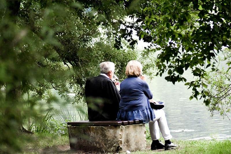 gamla par sitter på bänken i parken