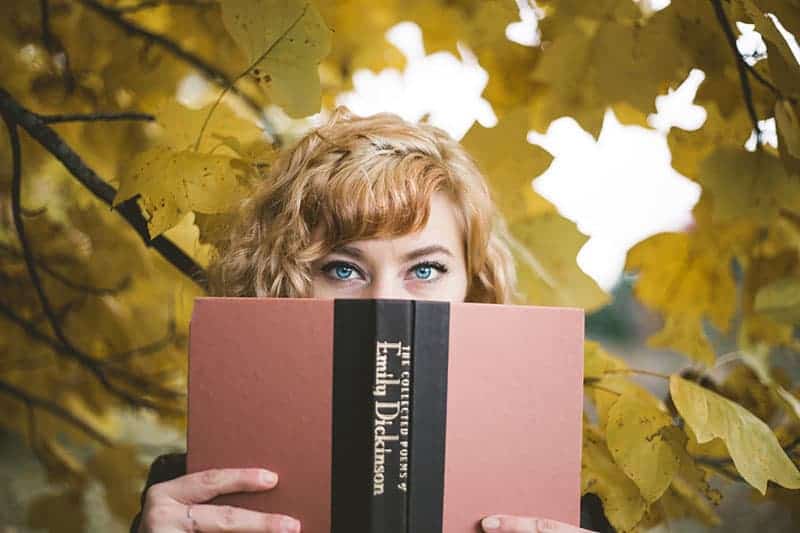kvinna med blå ögon som håller en bok