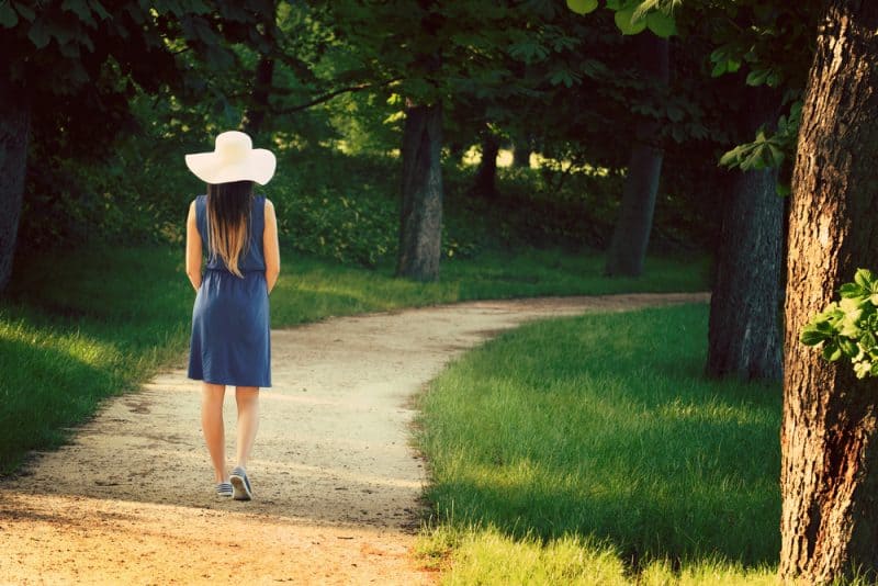 kvinna som bär hatt som går ensam