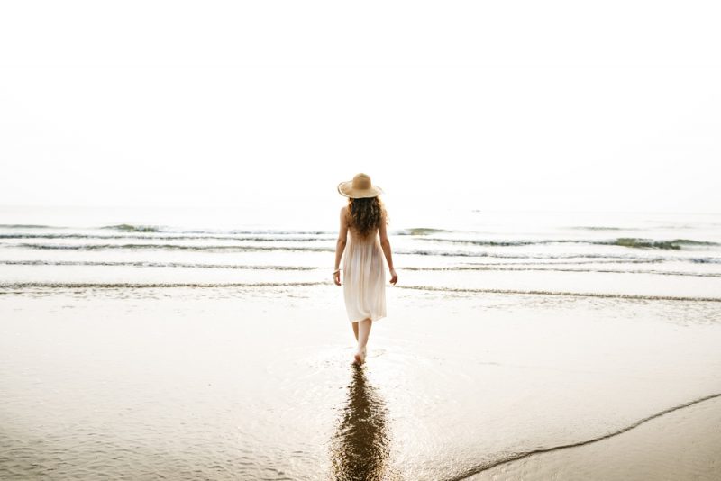 kvinna som går på stranden ensam
