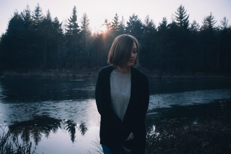 kvinna som står ensam nära sjön