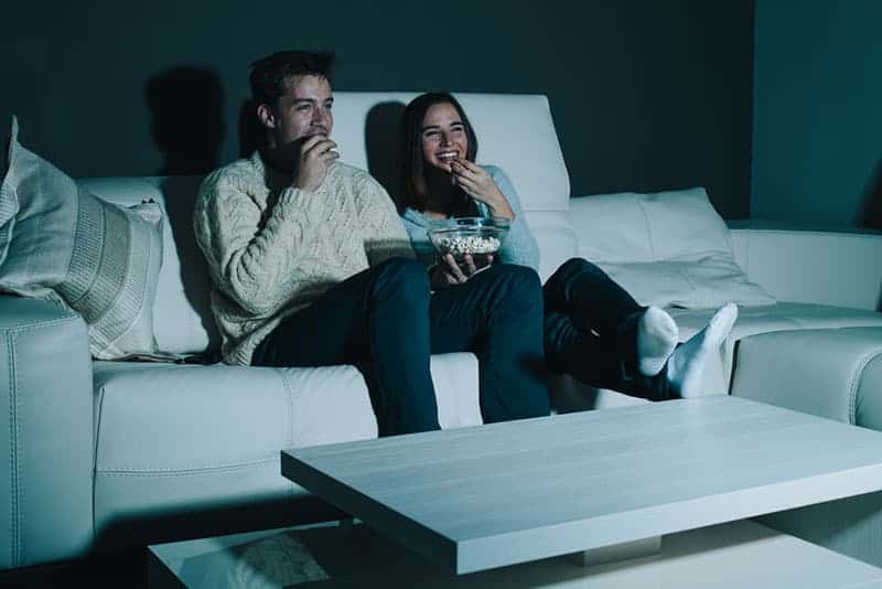 lyckliga par tittar på tv