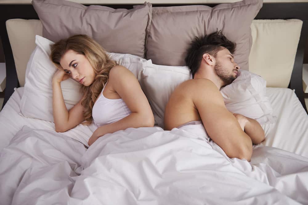 man och kvinna som ligger i sängen efter argument