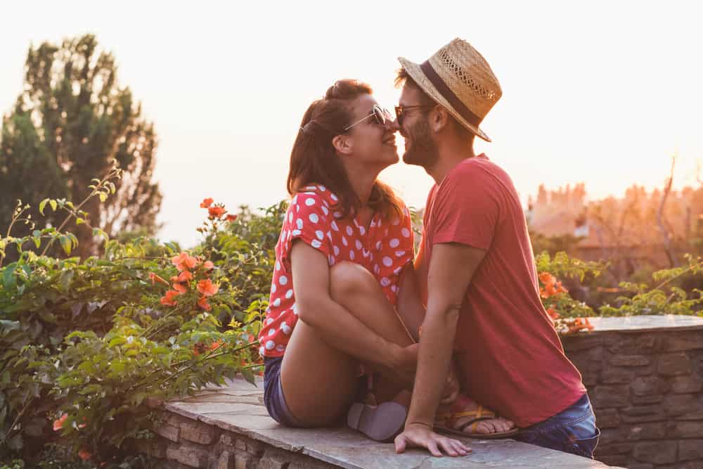 romantiskt Ungt par som kysser på balkongen