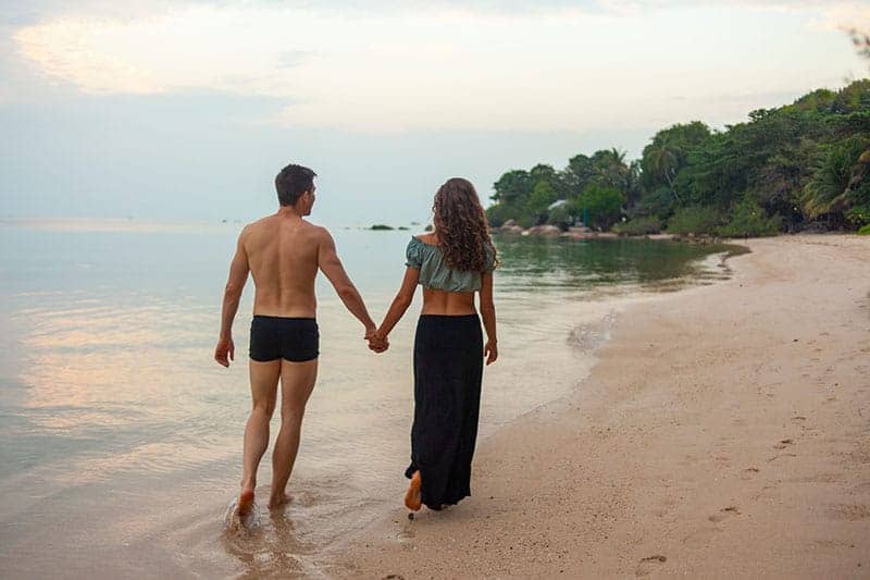 ungt par som går på stranden