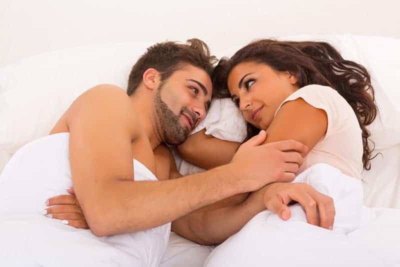 ungt par som ser varandra i sängen