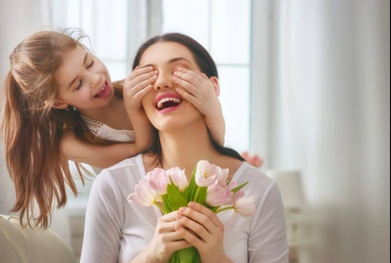 Barndotter gratulerar mamma och ger blommorna tulpaner
