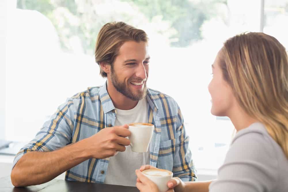 Lyckliga par som tycker om en kaffe på kaféet