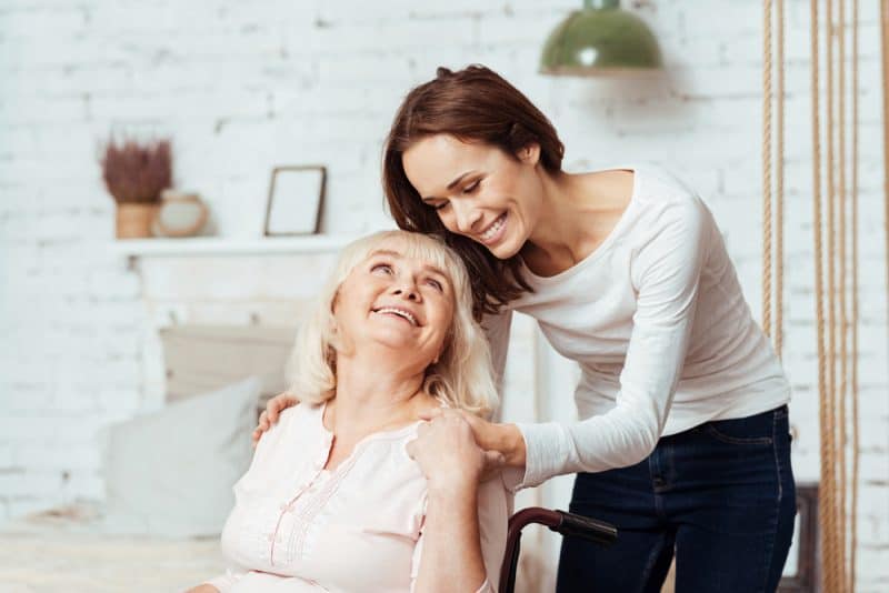 Positiv kvinna som tar hand om sin mormor
