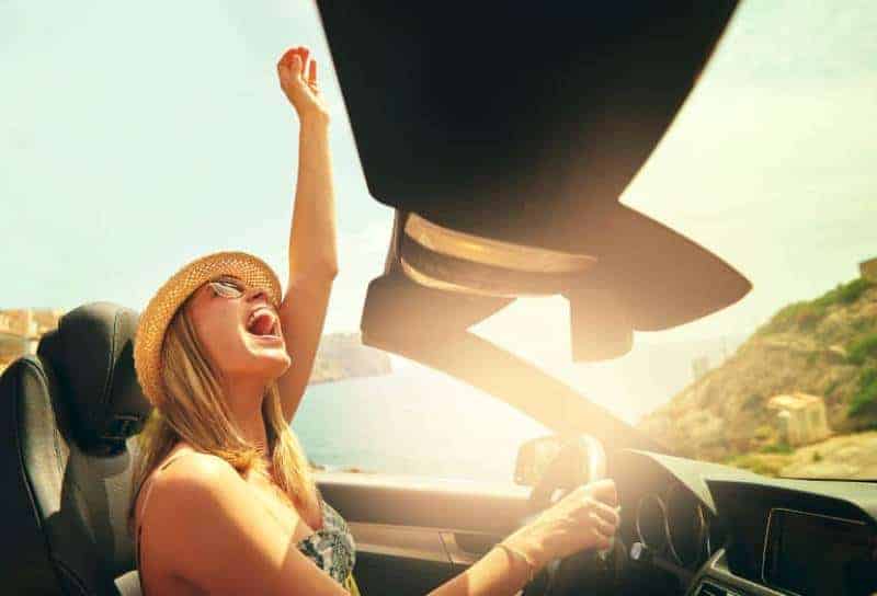glad kvinna som kör taklös bil