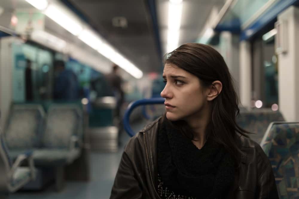 ledsen kvinna som sitter i tåget ensam