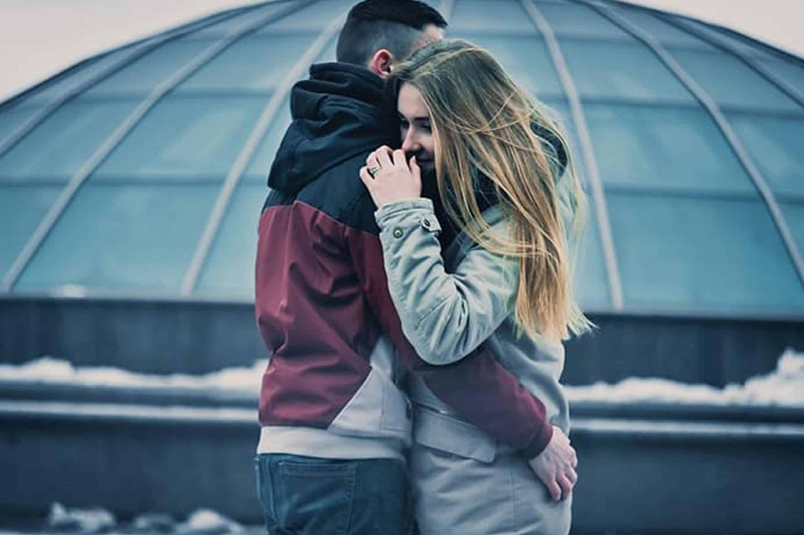 man och kvinna kram på vintern