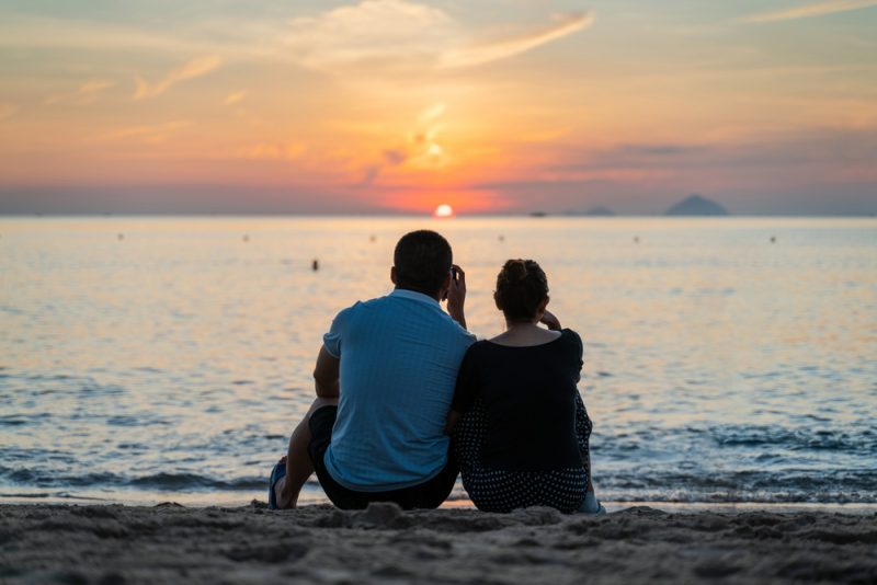 man och kvinna sitter på stranden