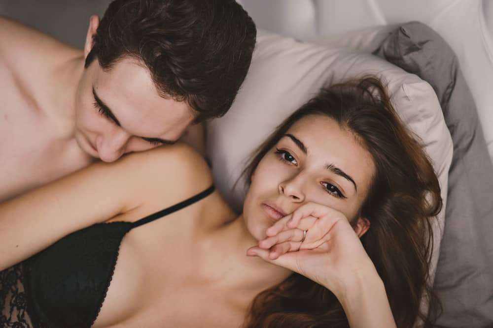 orolig kvinna i sängen med mannen