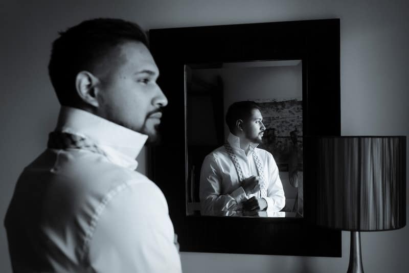 svartvitt foto av mannen som står framför spegeln