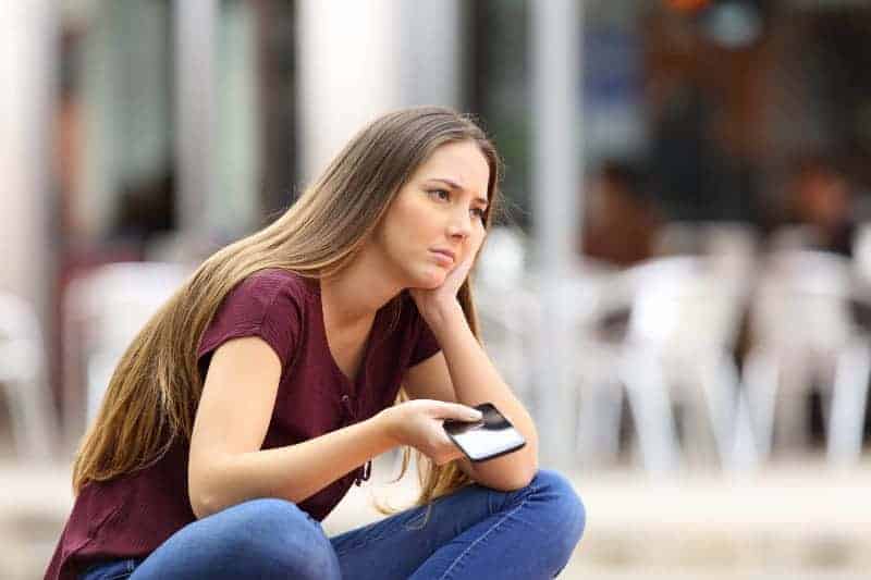 tankeväckande kvinna som skriver på sin telefon på gatan