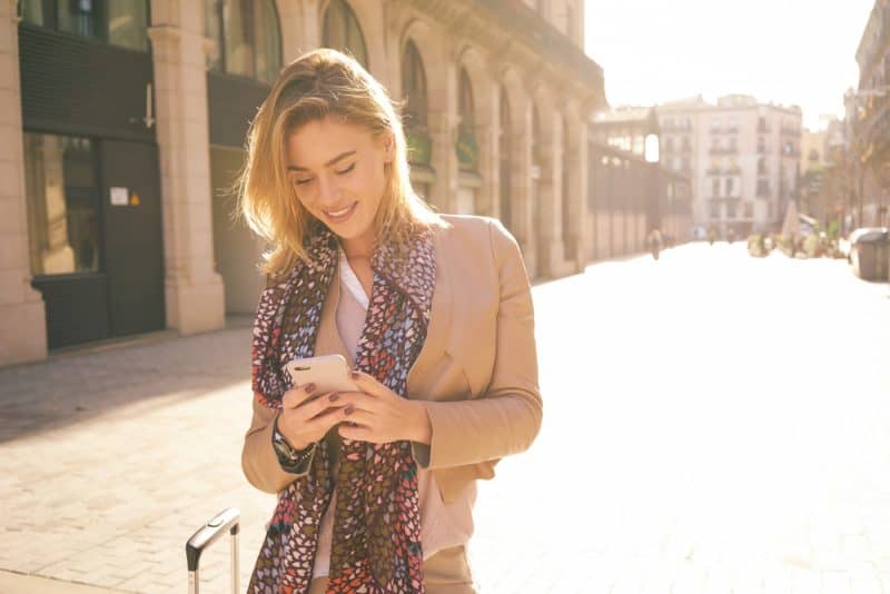 underbar vacker ung kvinna med blonda hårmeddelanden på smarttelefonen