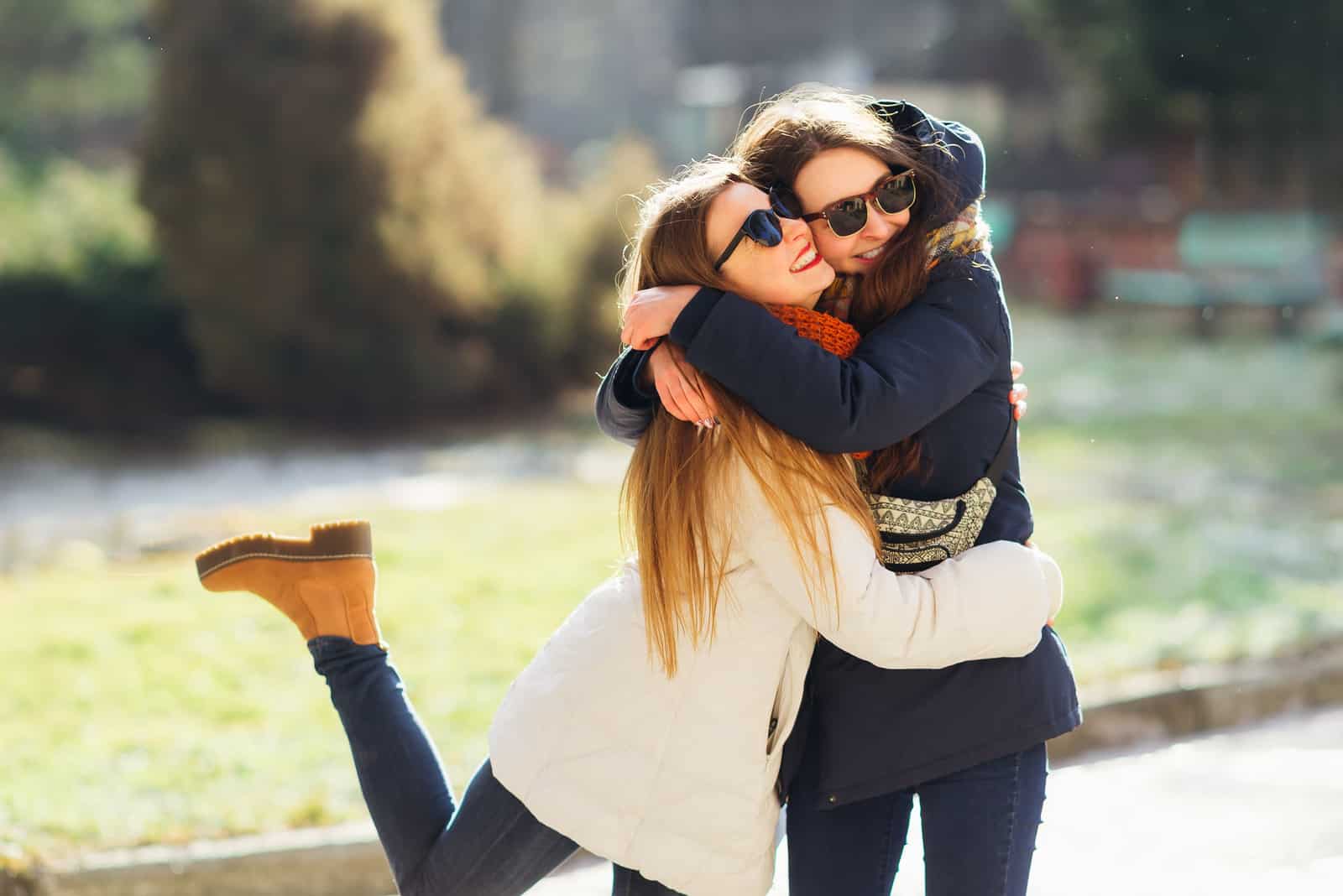 Ung flicka som kramar hennes äldre syster som ler