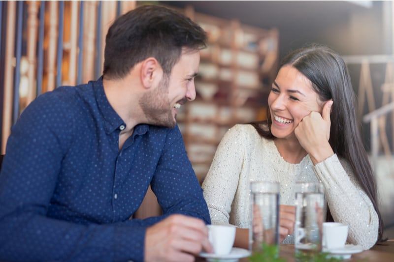 ett leende älskande par som talar på ett kafé