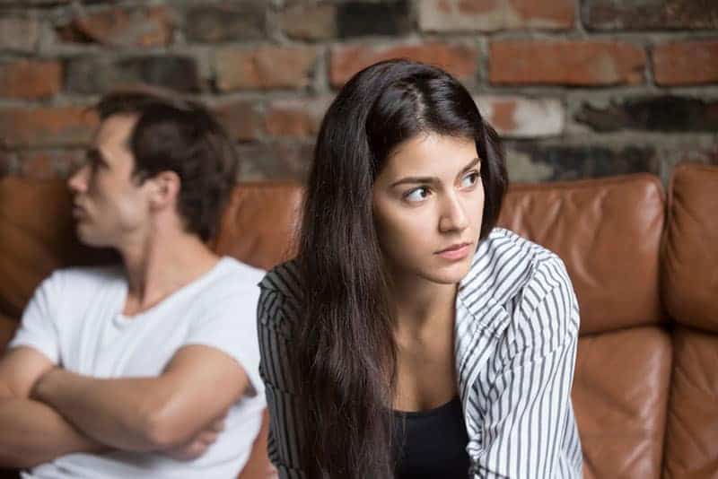 fundersam kvinna som sitter med sin man hemma
