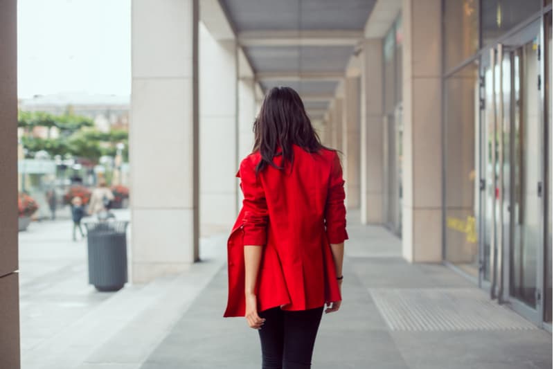 kvinna går utomhus i casual casual röd kostym