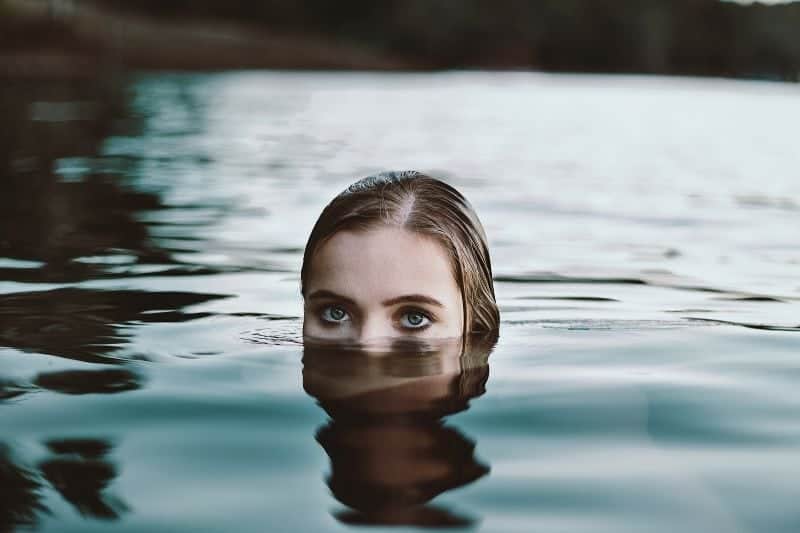 kvinna i vatten dykar ut