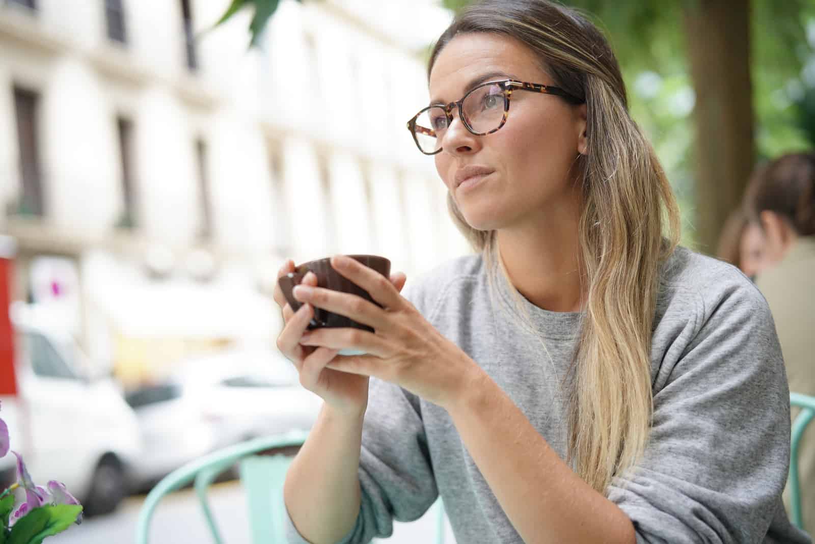 kvinna som bär glasögon som dricker kaffe