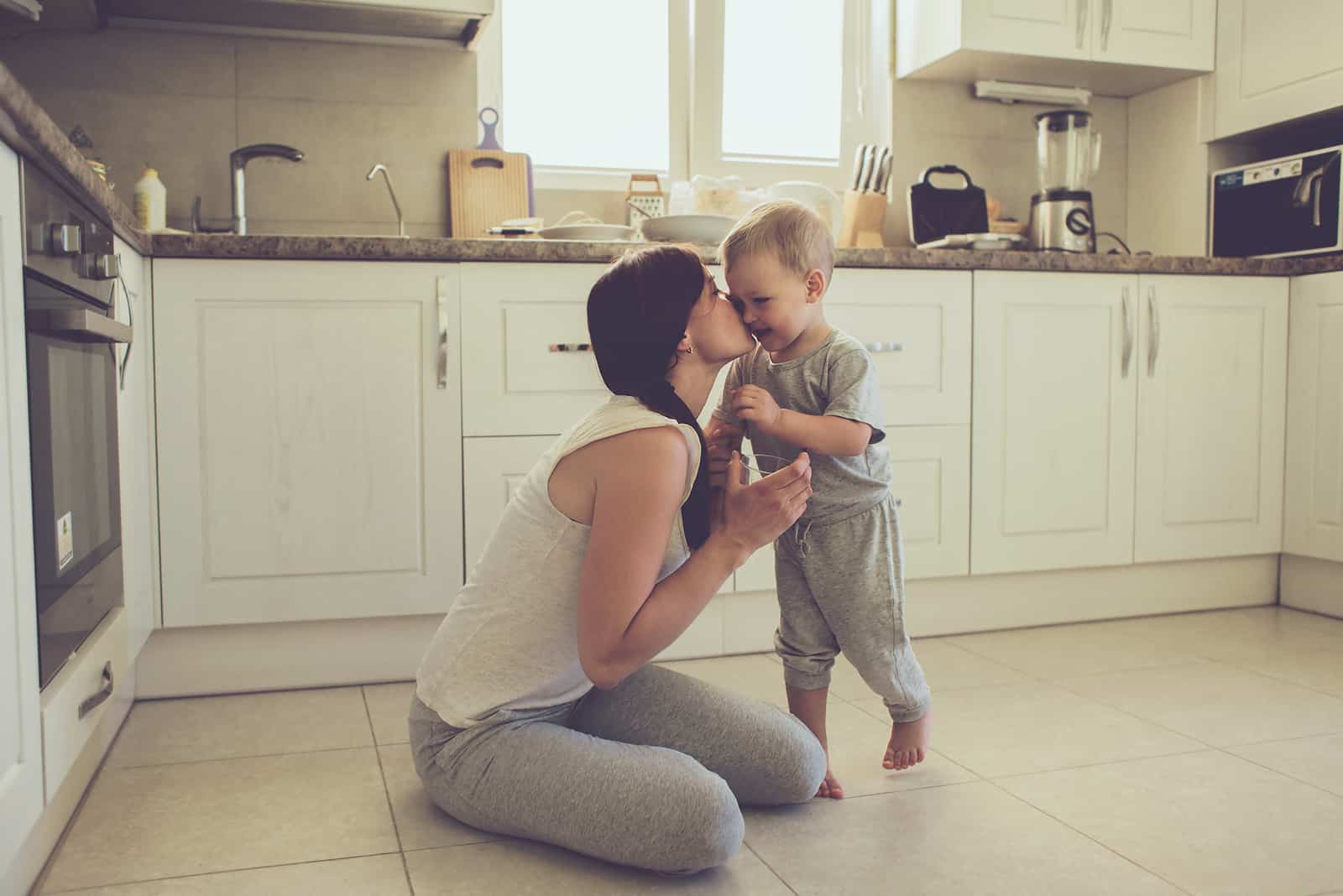 mamma kysser sitt barn i köket