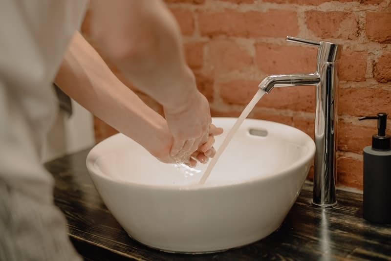 mannen tvättar händerna