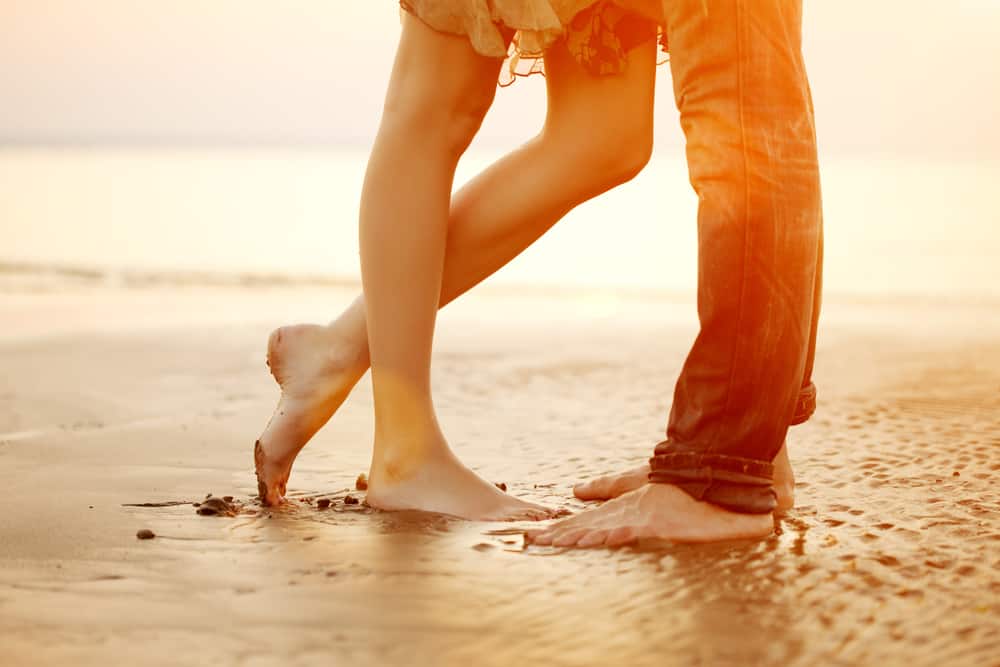 par kramar på stranden vid solnedgången